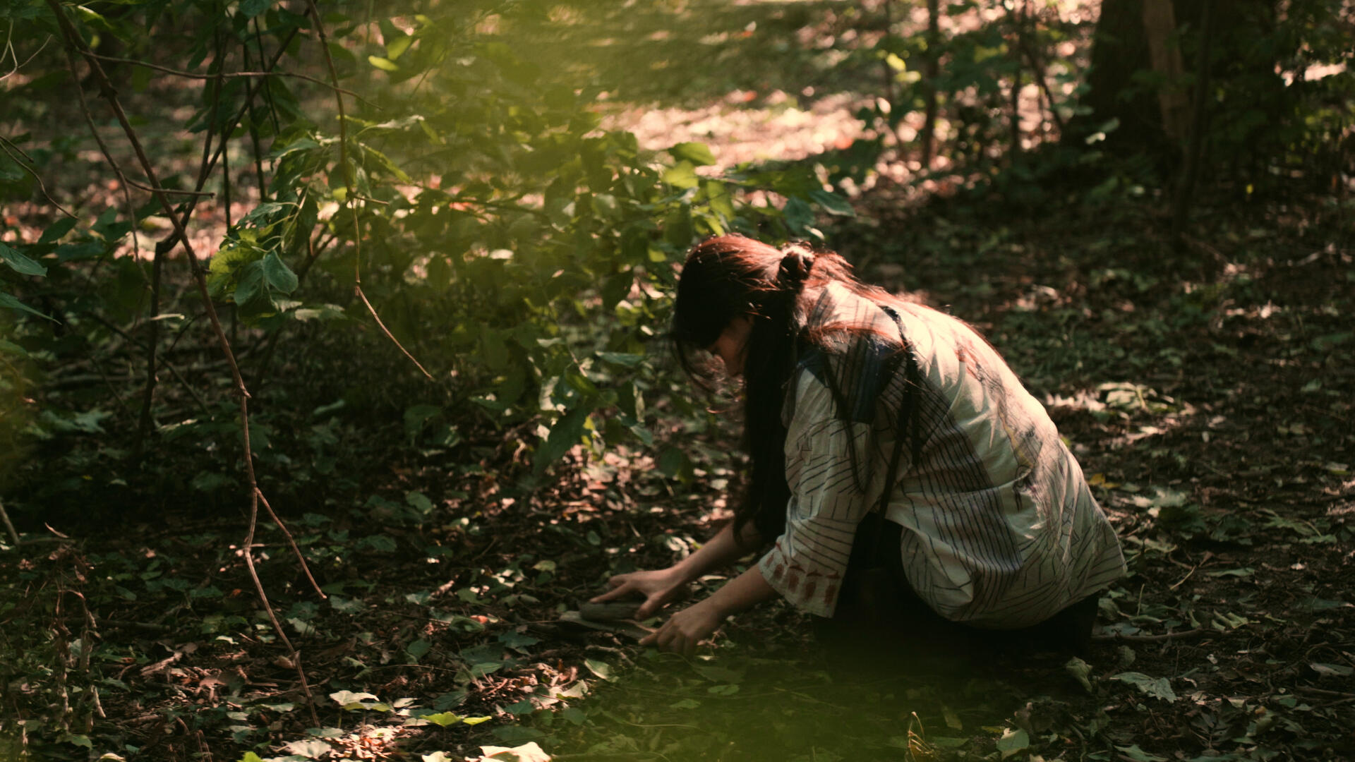 Junge Frau im Wald, sucht nach Klangmaterialien