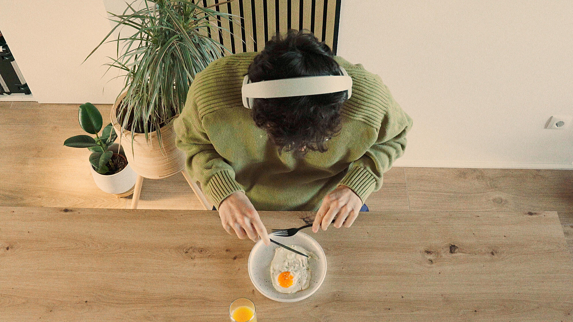 Mann am Frühstückstisch, Vogelperspektive, isst Spiegelei, Kopfhörer